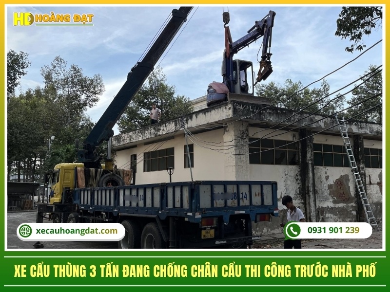 xe cẩu thùng 3 tấn đang chống chân cẩu thi công trước nhà phố